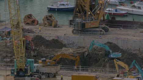En-Hong-Kong,-China,-Se-Están-Realizando-Trabajos-De-Construcción:-Excavadoras-Cavando-Terreno