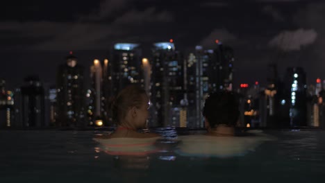 En-La-Piscina-En-La-Azotea-De-Un-Hotel-En-Kuala-Lumpur-Malasia-Pareja-Enamorada-Mirando-A-La-Ciudad-De-Noche