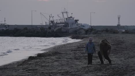 Mutter-Und-Kind-Werfen-Steine-Ins-Meer