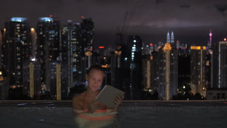 Im-Pool-Auf-Dem-Dach-Eines-Hotels-In-Kuala-Lumpur,-Malaysia-Frau-Arbeitet-An-Einem-Tablet