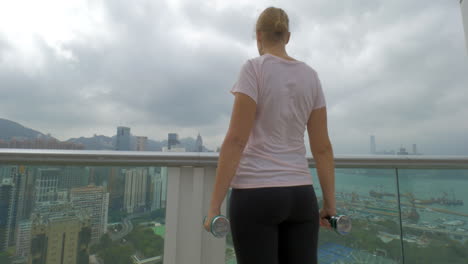 Frau-Macht-Schulterübungen-Auf-Dem-Balkon-Hongkong,-China