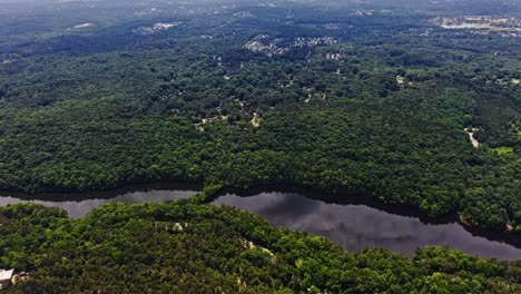 Aerial-birds-eye-shot-of-river,-green-forest-landscape-during-daytime-in-Stone-Mountain,-GA