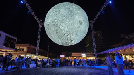 Gran-Exhibición-De-Arte-De-Luna-Brillante-En-La-Plaza-De-La-Ciudad-Por-La-Noche,-Gente-Tomándose-Selfies-Con-Superluna,-Timelapse