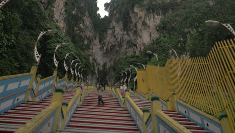 En-Las-Cuevas-De-Batu-Se-Ven-Largas-Escaleras-Y-Montañas-Con-Vegetación.