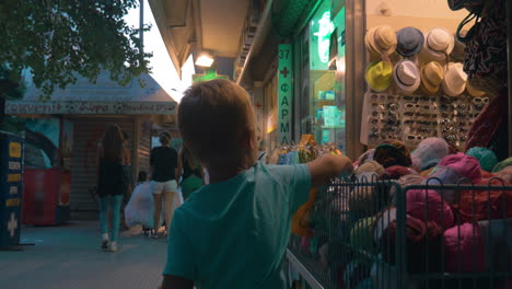 Little-boy-walking-down-the-street-with-shops