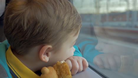 In-Saint-Petersburg-Russia-in-train-rides-a-little-boy-who-looks-out-the-window-and-holding-a-toy