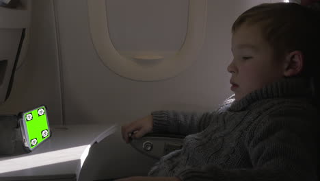 Niño-Mirando-Algo-En-El-Teléfono-Inteligente-En-La-Clave-Cromática-Del-Avión