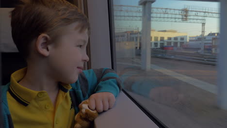 En-San-Petersburgo,-Rusia,-En-Tren-Viaja-Un-Niño-Que-Mira-Por-La-Ventana-Y-Sostiene-Un-Juguete.