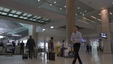 Personas-Con-Bolsas-De-Viaje-En-El-Aeropuerto-De-Seúl,-Corea-Del-Sur.