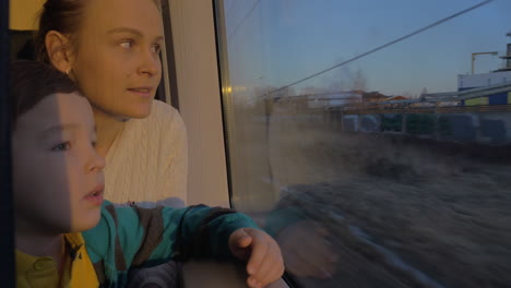En-San-Petersburgo,-Rusia,-En-Tren,-Viaja-Una-Joven-Madre-Con-Un-Hijo-Y-Mirando-Por-La-Ventana.