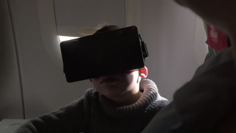 Im-Flugzeug-Sitzt-Ein-Kleiner-Junge-Mit-Virtual-Reality-Brille
