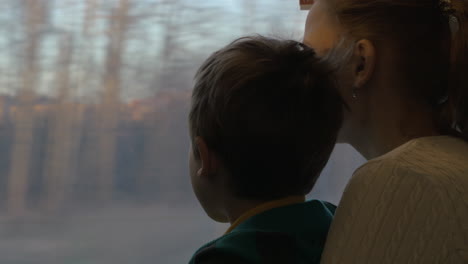 Mother-and-child-looking-out-train-window-during-the-travel