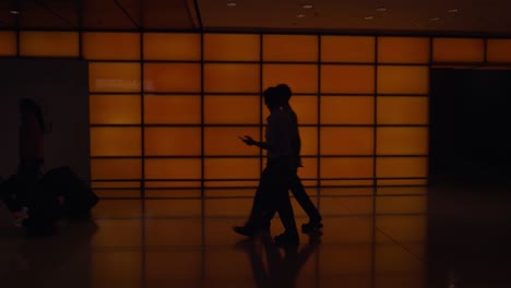 People-with-luggage-in-poor-lighted-corridor-of-airport-terminal