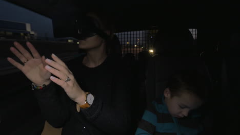 In-Nea-Kallikratia-Greece-in-car-rides-a-young-mother-with-virtual-reality-glasses-and-near-sitting-her-little-son
