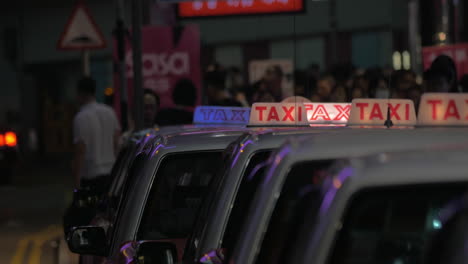 Vista-Nocturna-De-La-Señal-De-Taxi-En-Los-Taxis-Esperando-A-La-Gente.