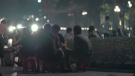 Un-Grupo-De-Jóvenes-Están-Sentados-Y-Hablando-Por-La-Noche-Al-Aire-Libre.