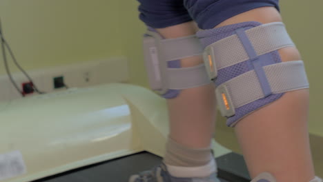 Kind-Trainiert-Auf-Dem-Laufband-Mit-Elektrischer-Stimulation-Der-Beine