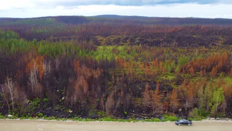 Aerial-footage-of-aftermath-biggest-wildfire-province-of-Quebec,-car-on-dirt-road