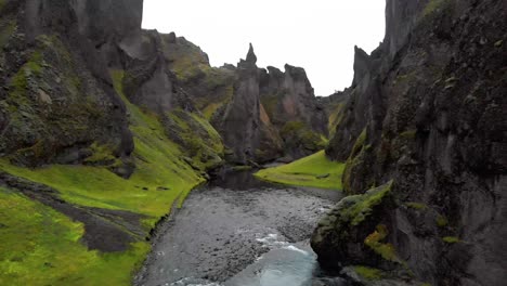 River-stream-flowing-below-sharp-jagged-rocks-of-Fjadrargljufur-canyon