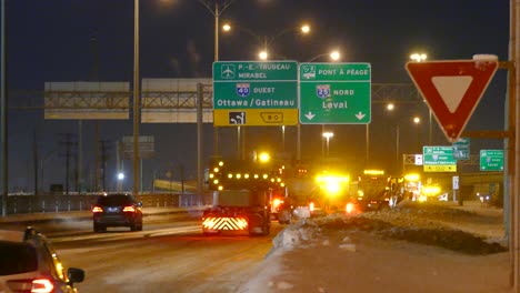 Pflügende-Lastwagen-Säubern-Eine-Autobahn,-Nach-Einem-Schneesturm,-Nachts,-Mit-Gelben-Lichtern