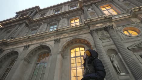 Young-tourist-woman-admiring-Louvre-museum-facade,-Paris