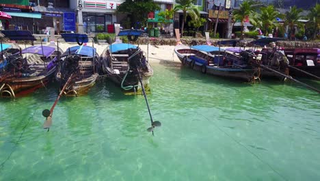 Motores-De-Barcos-De-Cola-Larga-Descansando-A-Lo-Largo-De-La-Costa-De-La-Playa-En-Koh-Phi-Phi,-Tailandia
