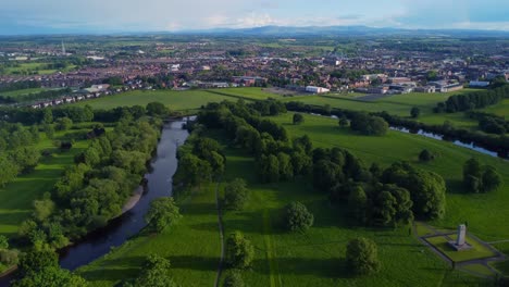 Aerial-drone-video-of-the-beautifully-green-Rickerby-Park-in-summer,-with-Carlisle-and-Lake-District-fells-in-the-background
