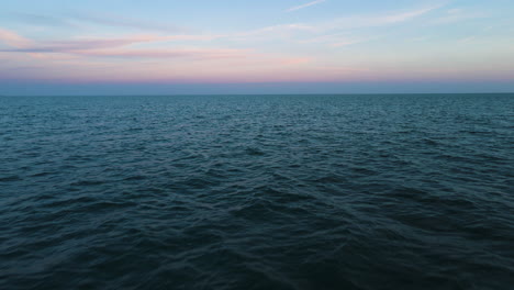 Sky-seamlessly-blends-into-ocean-water-ripples,-zen-calming-nature-background-of-water