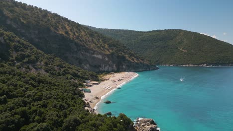 Panorama-Dolly-über-Dem-Strand-Und-Der-Küste-Der-Albanischen-Riviera-Mit-Liegestühlen-Und-Sonnenschirmen