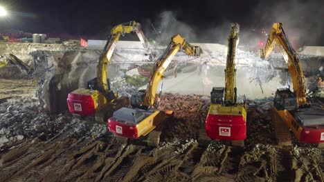 Bagger-Brechen-Nachts-Einen-Damm-Ab-Und-Beleuchten-Die-Baustelle-Mit-Hellen-Lichtern