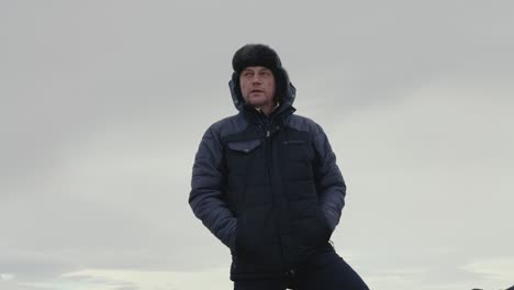 Male-tourist-stand-and-enjoy-Icelandic-nature-during-windy-overcast-day