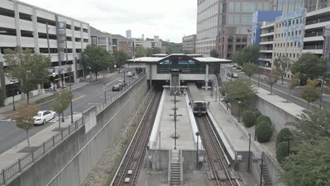 Aerial-approaching-shot-of-Lindbergh-Marta-Station-with-metro-and-driving-cars-in-Atlanta