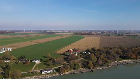 Aerial-parallax-orbit-around-Lake-Erie-coastal-shores-with-farm-land-fields-and-turbines-behind