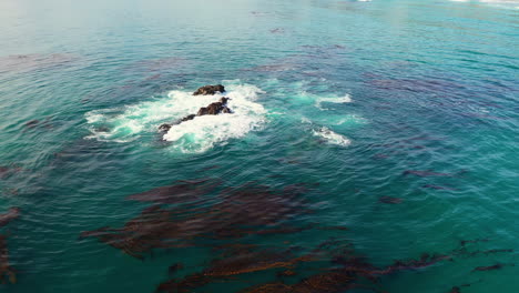 Drohne-Schoss-über-Einen-Felsen-Im-Seichten-Wasser-Eines-Kiesstrandes-In-Monterey,-Kalifornien,-USA