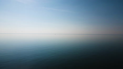 Misty-fog-above-ocean-or-lake-water-blurs-the-horizon,-soothing-blue-gradient-background