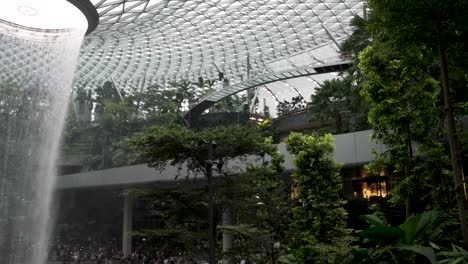 The-Rain-Vortex-Indoor-Waterfall-At-Jewel-Changi-Airport-Singapore-With-Skytrain's-Going-Past