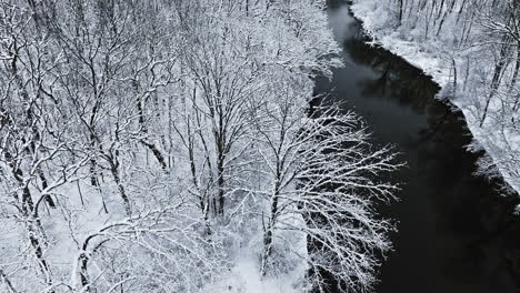 Overhead-drone-view-traversing-the-pristine-winter-beauty-of-the-snow-covered-Huron-River-Valley
