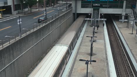 Aerial-view-of-Metro-leaving-marta-Station-in-Atlanta-,-passenger-walking-on-track-platform