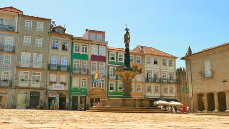 Burgbrunnen-Und-Farbenfrohe-Gebäudefassaden-In-Largo-Do-Paco,-Braga,-Portugal