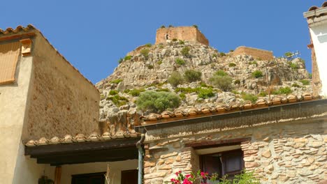 Detail-Einer-Mit-Steinen-Erbauten-Residenz-Und-Einer-Burg-Im-Hintergrund-In-Der-Altstadt-Von-Borriol,-Spanien