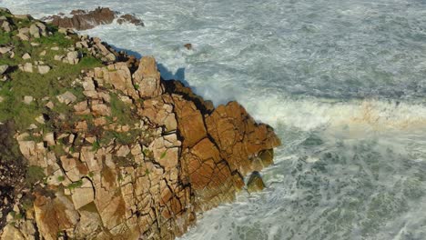 Foamy-Sea-Waves-Breaking-On-Rocky-Cliff-In-Carballo,-A-Coruña,-Spain---aerial-shot