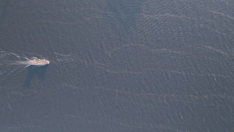 Top-down-aerial-video-of-a-boat-navigating-the-Amazon-River-of-the-coast-of-Manaus,-Brazil