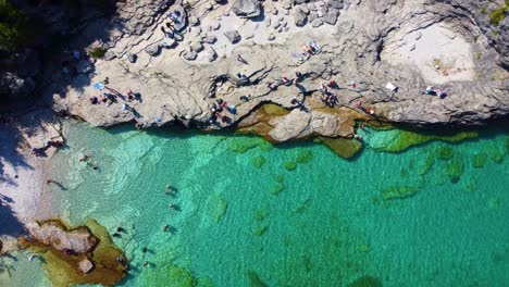 People-enjoy-rocky-coast-of-Bruce-peninsula-and-crystal-clear-lake-water,-aerial-top-down-view