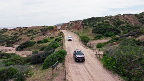 Drone-frontal-tracking-follows-SUV-driving-along-sandy-path-out-to-beach-in-Baja-California-Sur