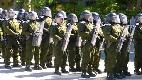 Pan-across-armed-police-men-in-riot-shield-protection-gear-at-G7-summit