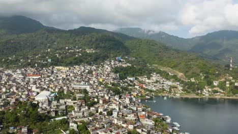 Aerial-pullback-reveals-stunning-sprawling-city-on-coast-of-Lake-Atitlan-Guatemala