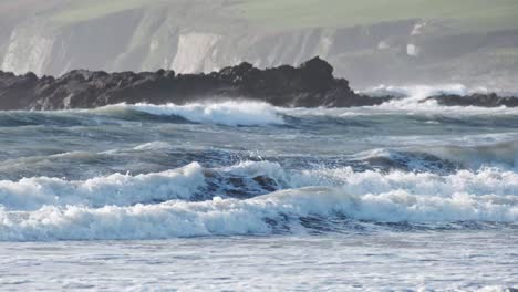 Two-kitesurfers-whizzing-by-in-rolling-waves-of-the-coast-of-Ireland