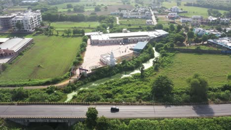 La-Cámara-Aérea-Del-Dron-Se-Mueve-Hacia-Un-Lado-Y-Hay-Muchos-Vehículos-Circulando-Por-La-Carretera-Frente-Al-Albergue.