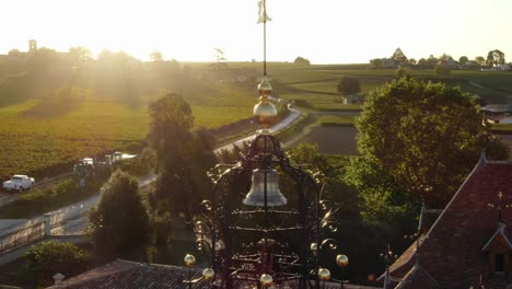 Drone-flying-around-bell-tower-of-Chateau-Angelus-winery,-Saint-Emilion-in-France