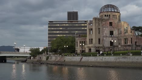 Das-Atombomben-Dom-Denkmal-In-Hiroshima-Neben-Dem-Motoyasu-Fluss-Kurz-Nach-Sonnenuntergang-Mit-Vorbeigehenden-Menschen